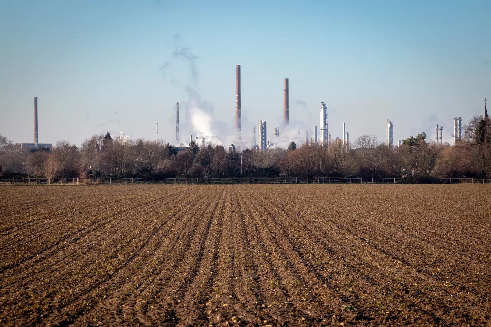 Schornsteine und Anlagen des Chempark Dormagen hinter einem Feld